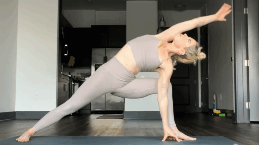 Doing a home yoga exercise routine with a YouTube video in a cozy sunlit living room