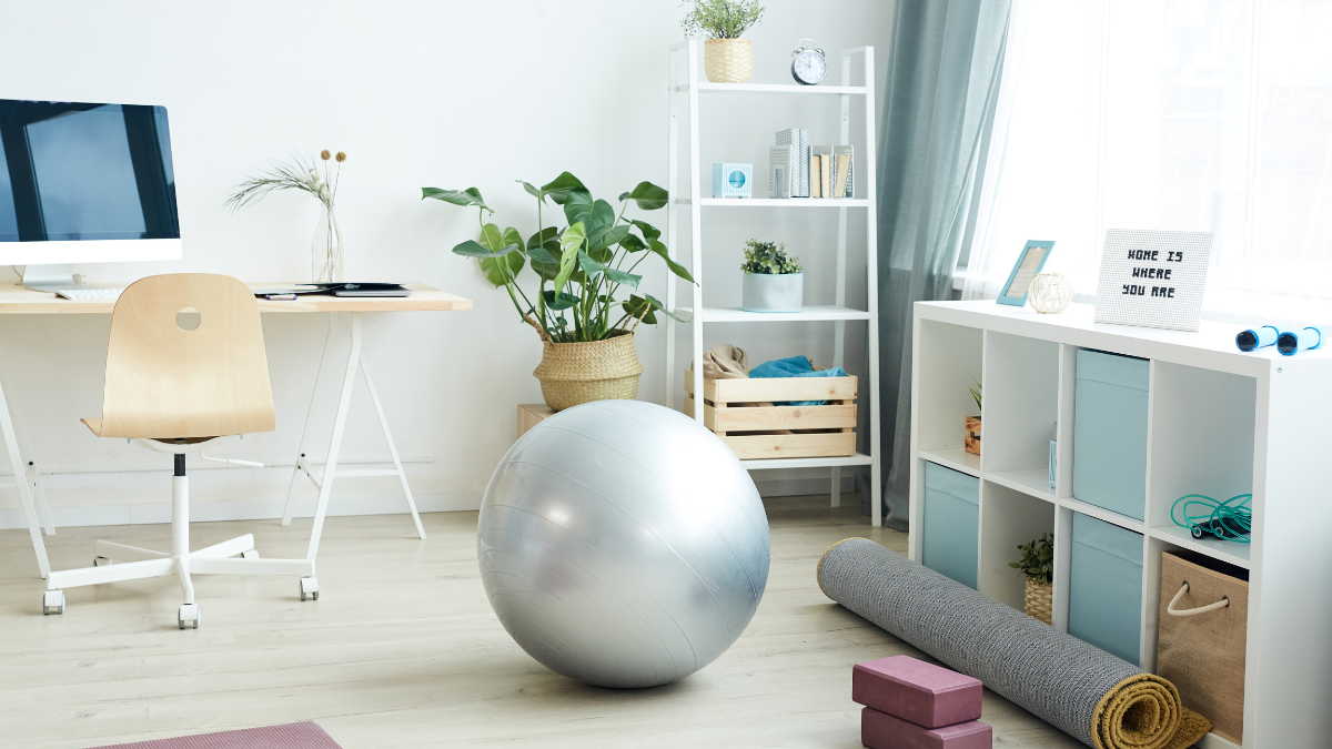 Home workout setup with yoga mat, yoga blocks, and a desk in a bright home office, representing a simple work-from-home exercise routine.